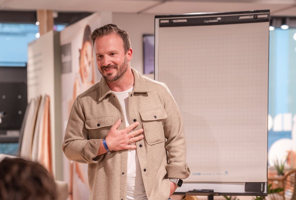 Daniel Augsten spricht vor einer Gruppe am Flipchart